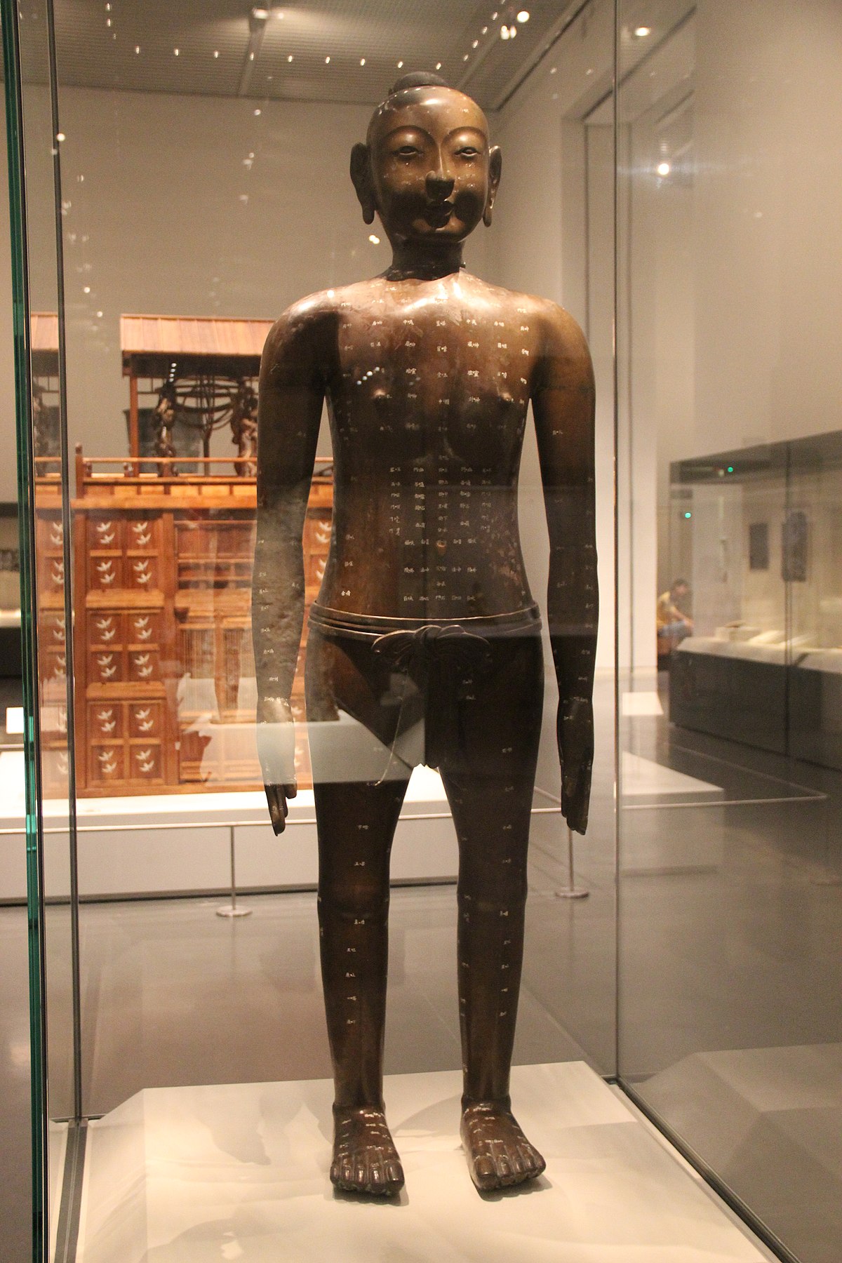 A photo of a Chinese statue with acupuncture designations on its body